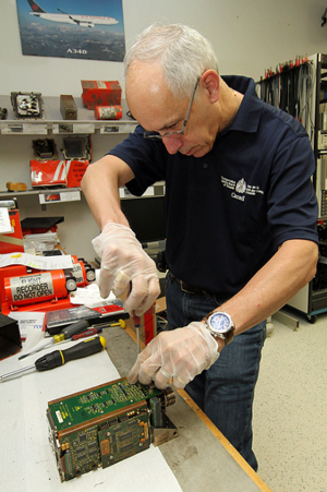 Ted Givins, manager of recorder and vehicle performance with the Transportation Safety Board, examines the cockpit voice recorder that was recovered from the scene of the Ornge helicopter crash near Moosonee, Ont. The helicopter crashed shortly after take-off on May 31, killing four people.  